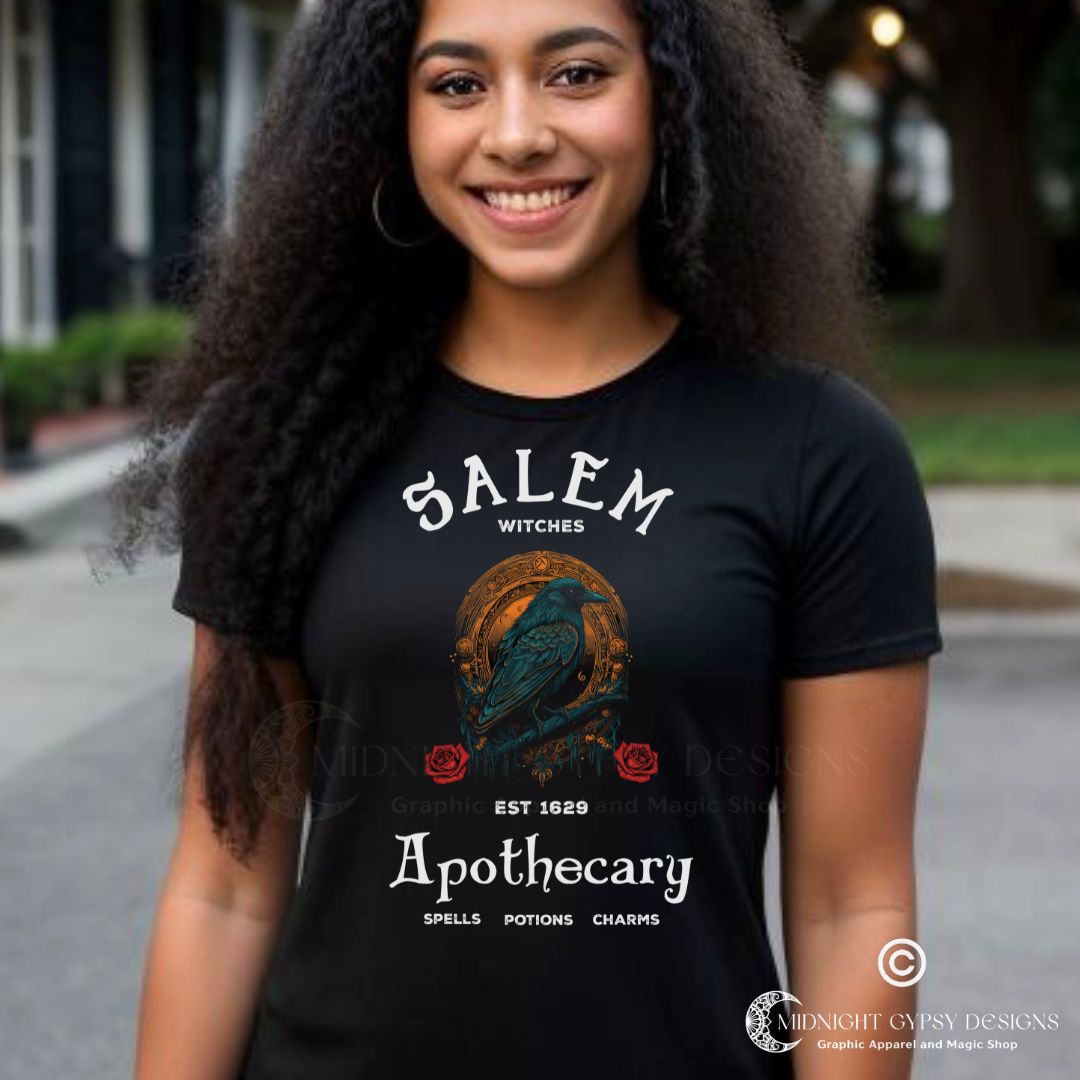 Young woman with long black hair standing outside wearing a black Salem Apothecary shirt with a black crow and two red roses created by graphic apparel company Midnight Gypsy Designs as part of their witchy and gothic apparel clothing line. Perfect Salam witch trials shirt, Salem Apothecary t-shirt, Salem Apothecary tee, Salem witch shirt, Salem witch tshirt, Salem witch tee, Salem witches shirt, Salem witches t-shirt, Salem witches tshirt, 1692 Salem witch trials shirt, and 1692 Salem witch trials tshirt.