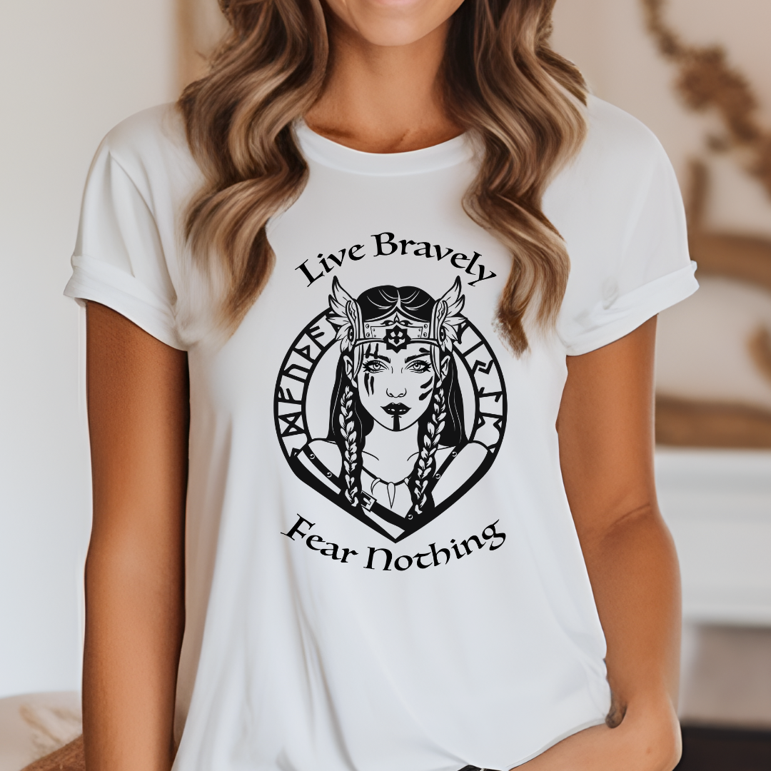 Young woman with long brown hair wearing a white Viking Warrior shirt that reads Live Bravely Fear Nothing with a shield maiden Viking Warrior woman with Futhark runes created by graphic apparel shop Midnight Gypsy Designs as part of their Viking Apparel Collection.