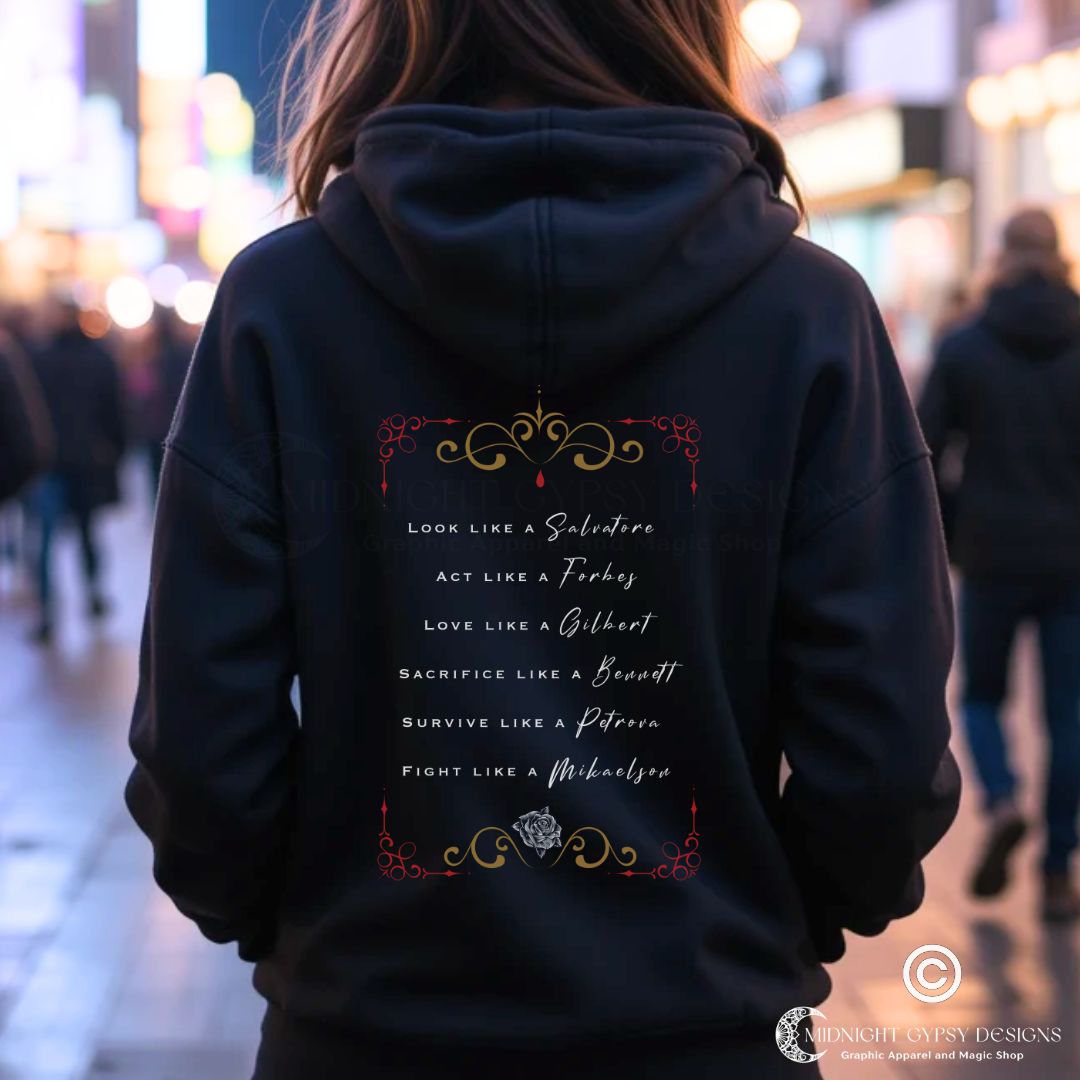 Young woman with brown hair standing outside at night with city lights wearing a black Mystic Falls hoodie that says Look Like a Salvatore, Act Like a Forbes, and Love Like a Gilbert with black rose and red blood drip created by graphic apparel company Midnight Gypsy Designs as part of their The Vampire Diaries apparel line. Perfect Vampire Diaries hoodie, Stefan Salvatore hoodie, Damon Salvatore hoodie, Mystic Falls shirt, Bonnie Bennett shirt, Caroline Forbes shirt, and Salvatore Brothers hoodie.