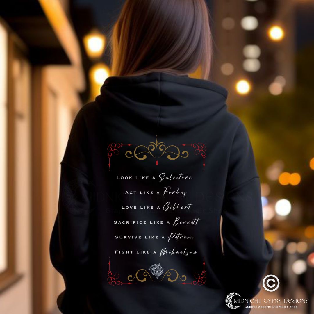 Young woman with brown hair standing outside at night with city lights wearing a black Mystic Falls hoodie that says Look Like a Salvatore, Act Like a Forbes, and Love Like a Gilbert with black rose and red blood drip created by graphic apparel company Midnight Gypsy Designs as part of their The Vampire Diaries apparel line. Perfect Vampire Diaries hoodie, Stefan Salvatore hoodie, Damon Salvatore hoodie, Mystic Falls shirt, Bonnie Bennett shirt, Caroline Forbes shirt, and Salvatore Brothers hoodie.