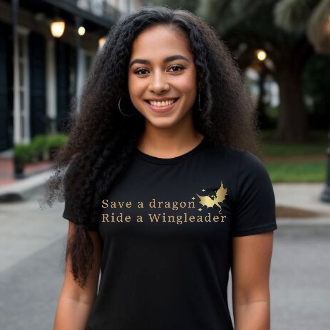Young woman with long black hair standing outside wearing a black Fourth Wing shirt that says Save a Dragon Ride a Wingleader with a dragon and stars created by graphic apparel company Midnight Gypsy Designs as part of its bookish merch collection for fantasy book readers and fans of the novel books Fourth Wing, Iron Flame, and Onyx Storm.