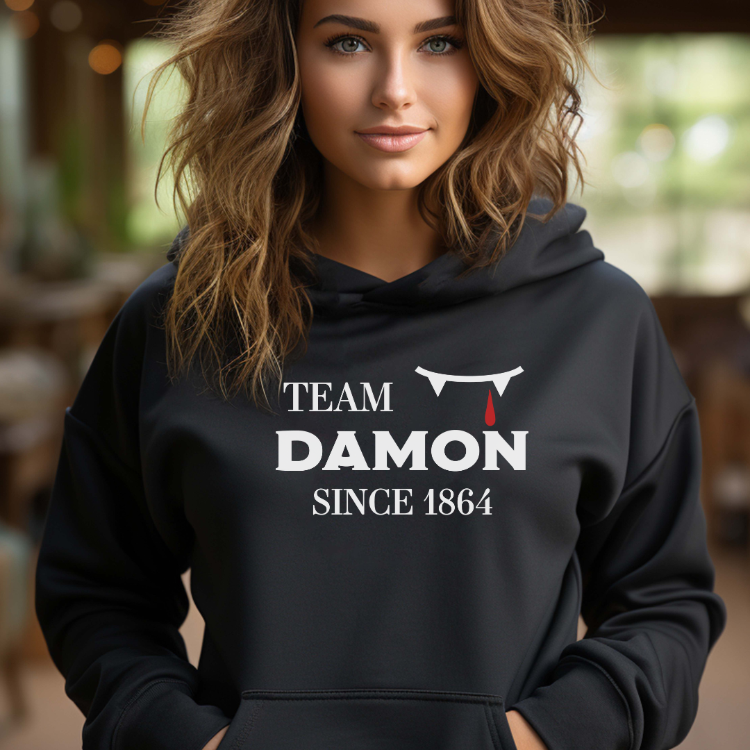 Team Damon Since 1864 hoodie with vampire teeth and blood drip created by graphic apparel company Midnight Gypsy Designs as part of their The Vampire Diaries mech collection. Perfect Vampire Diaries shirt, team Damon shirt, team Damon hoodie, Damon Salvatore hoodie, and Mystic Falls hoodie!