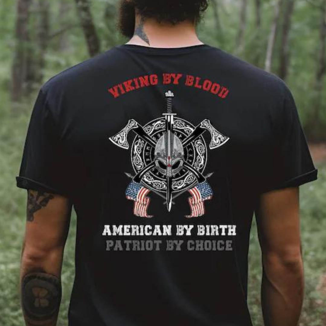 Man with tattoos wearing a black Viking By Blood American By Birth Patriot By Choice patriotic pride shirt created by graphic apparel shop Midnight Gypsy Designs as part of their Norse Viking shirt collection.
