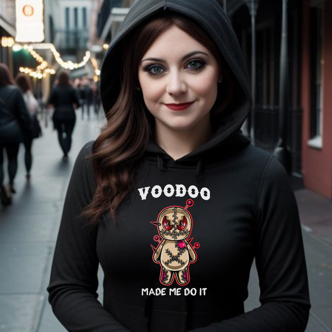 Young woman with red hair standing on Bourbon Street in New Orleans wearing a black VooDoo Made Me Do It Hoodie with a Voodoo doll with pins on front created by graphic apparel company Midnight Gypsy Designs.