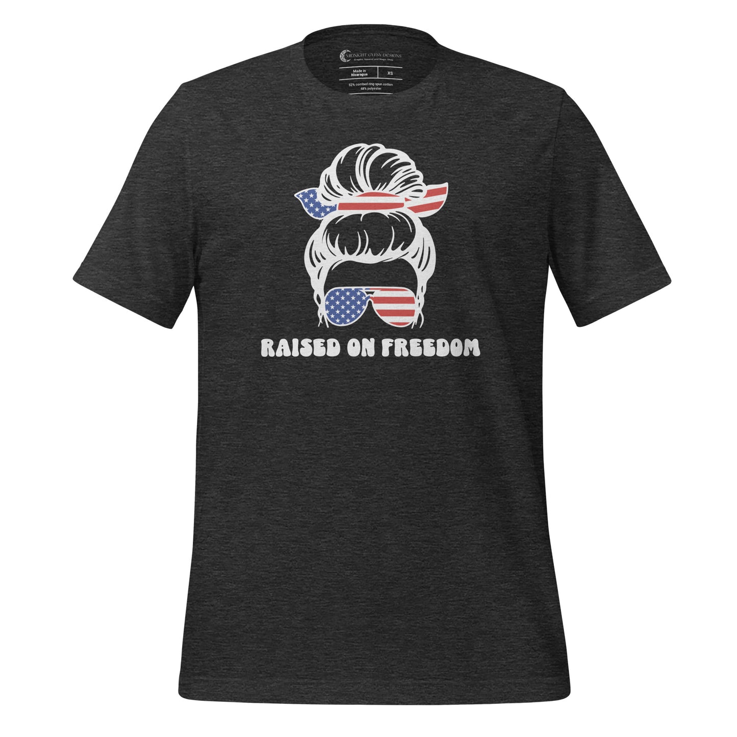 Grey Raised on Freedom shirt with graphic of a woman with an American flag hair tie and sunglasses created by graphic apparel company Midnight Gypsy Designs as part of their patriotic apparel collection. Perfect USA patriotic shirt, All American Girl shirt, girl power shirt, American pride shirt, USA shirt, USA flag shirt, womens patriotic shirt, Fourth of July shirt, Patriotic pride shirt, American flag shirt, Independence Day shirt, & American girl shirt.