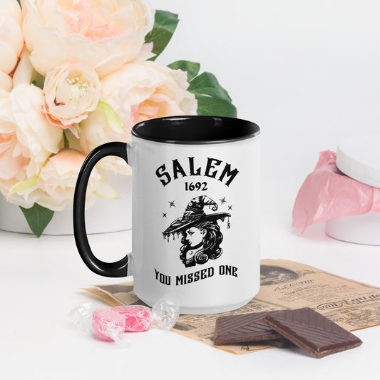 Black and white ceramic coffee mug with 1692 Salem Witch Trials You Missed One written in black letters and a witch in a witch hat with stars from apparel shop Midnight Gypsy Designs.