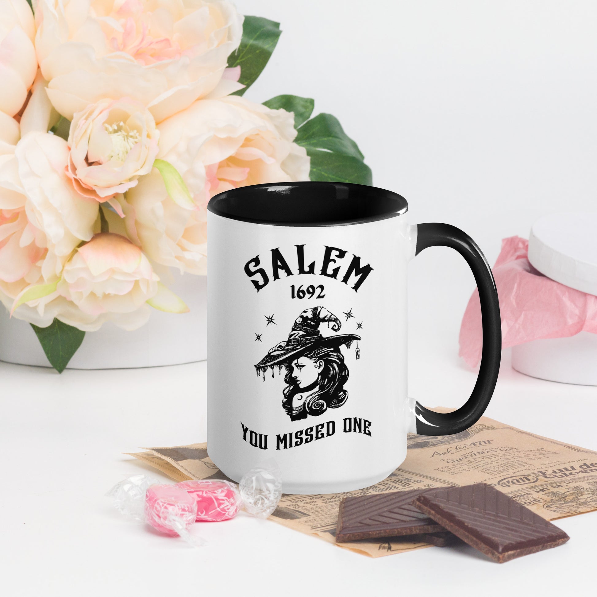 Black and white ceramic coffee mug with 1692 Salem Witch Trials You Missed One written in black letters and a witch in a witch hat with stars from apparel shop Midnight Gypsy Designs.