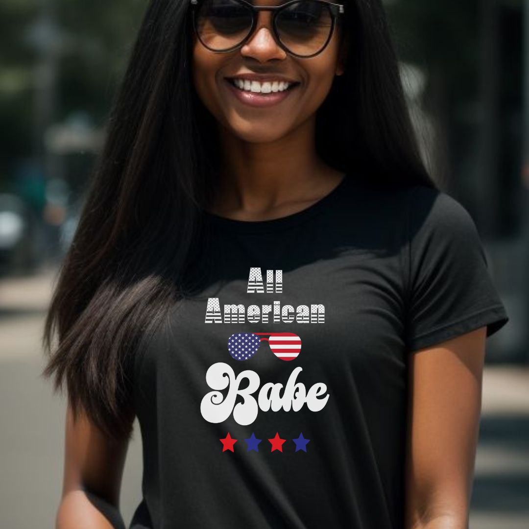 Young woman smiling with long black hair wearing black sunglasses and a black All American Babe t-shirt with red and blue stars created by patriotic apparel clothing shop Midnight Gypsy Designs.