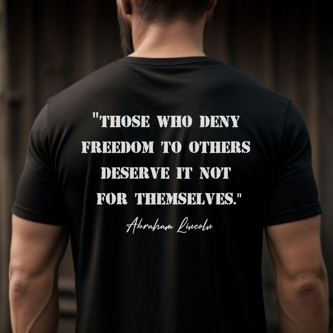 Young man with beard and short hair wearing a black patriotic t-shirt that says those who deny freedom to others deserve it not for themselves by Abraham Lincoln created by apparel shop Midnight Gypsy Designs.