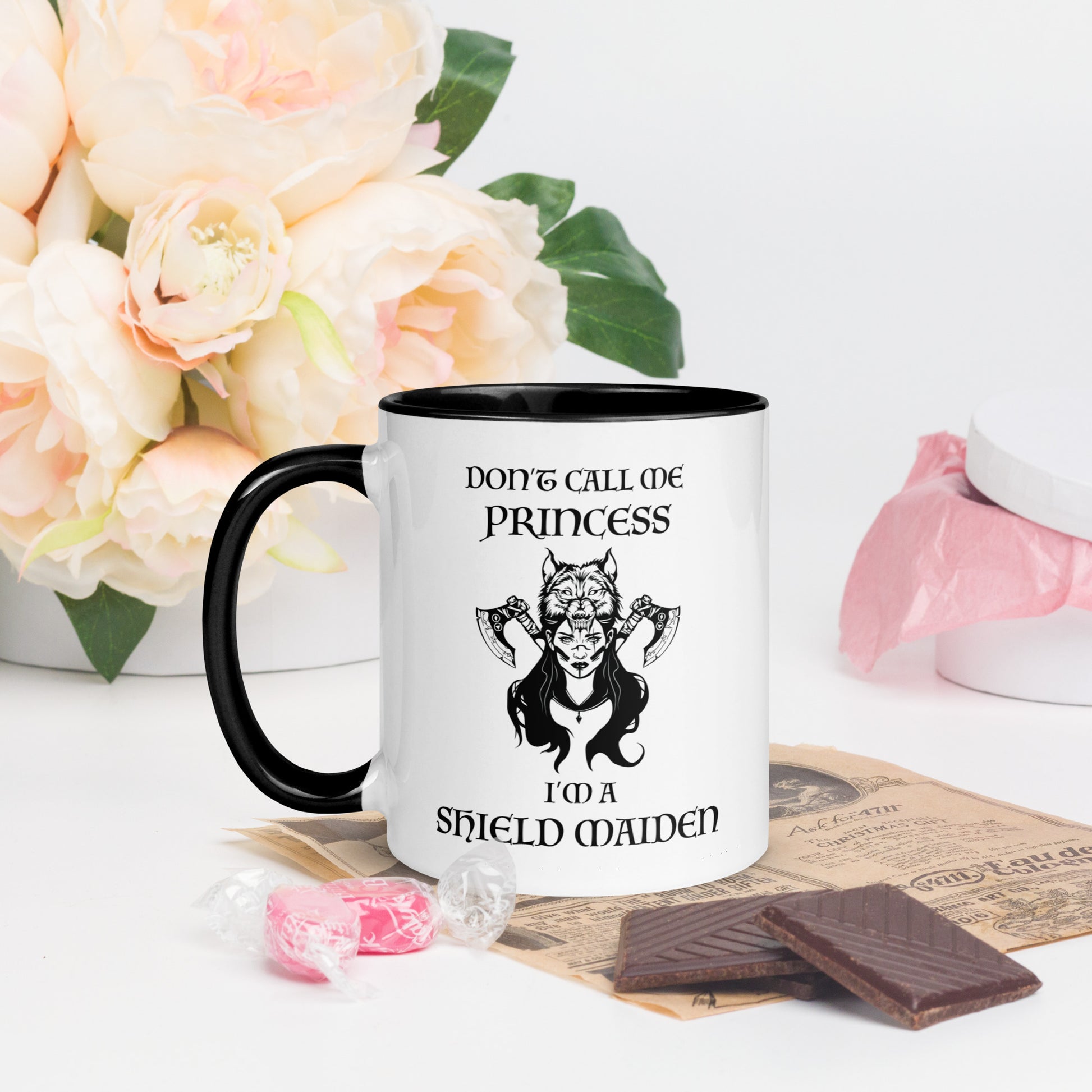 Black and white ceramic coffee mug with lettering that says Don't Call Me Princess I'm a Shield Maiden with a female Viking Warrior with Norse Viking axes and a wolf created by apparel shop Midnight Gypsy Designs.