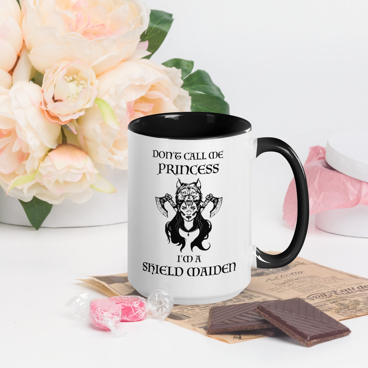 Black and white ceramic coffee mug with lettering that says Don't Call Me Princess I'm a Shield Maiden with a female Viking Warrior with Norse Viking axes and a wolf created by apparel shop Midnight Gypsy Designs.