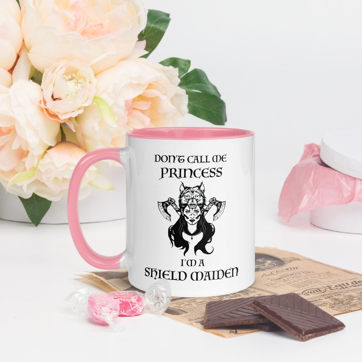 Pink and white ceramic coffee mug with lettering that says Don't Call Me Princess I'm a Shield Maiden with a female Viking Warrior with Norse Viking axes and a wolf created by apparel shop Midnight Gypsy Designs.