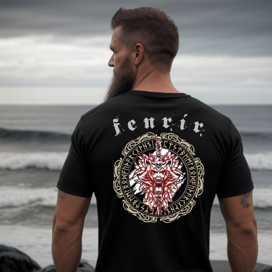 Norse Viking man in front of ocean wearing a black t-shirt that says Fenrir with a wolf, sword, and the vegvisir amulet with Futhark runes created by Viking apparel shop Midnight Gypsy Designs.