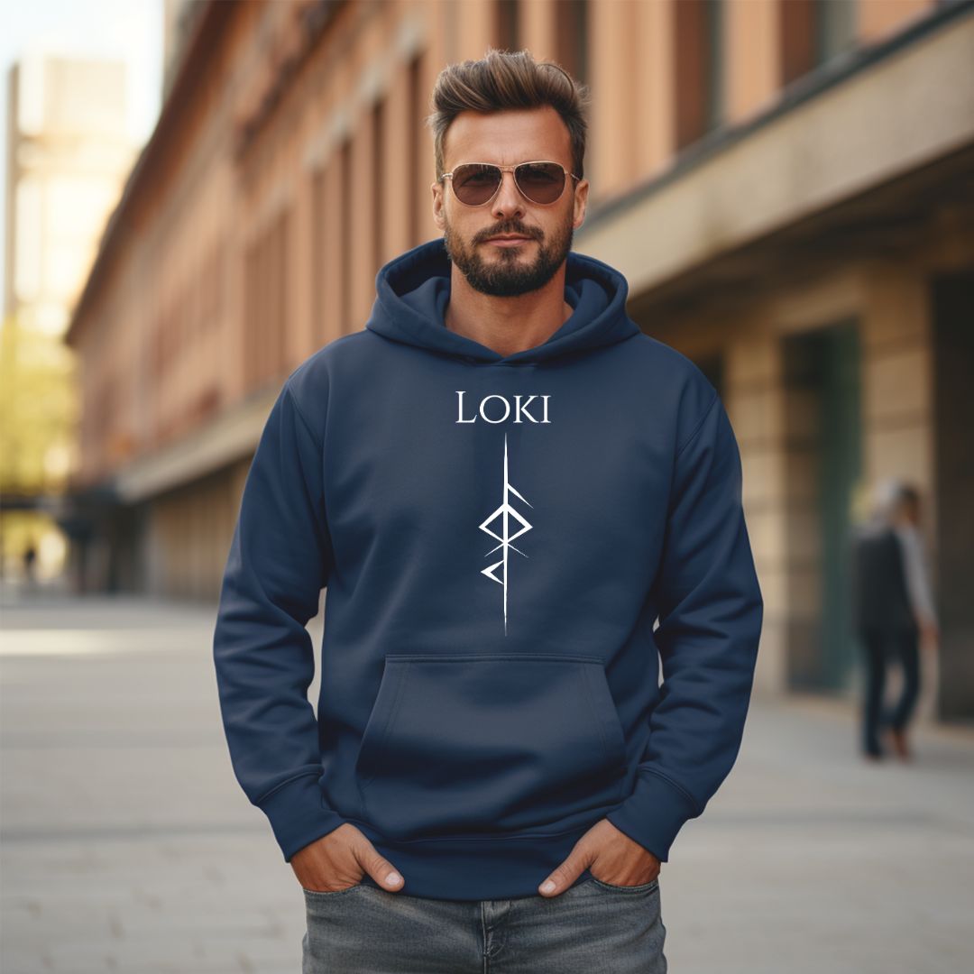 Man standing outside on sidewalk with a brown beard and mustache wearing aviator sunglasses and a Gildan navy hoodie that reads Loki with the Loki Futhark rune symbol for Loki God of Mischief created by Norse Viking apparel shop Midnight Gypsy Designs. 