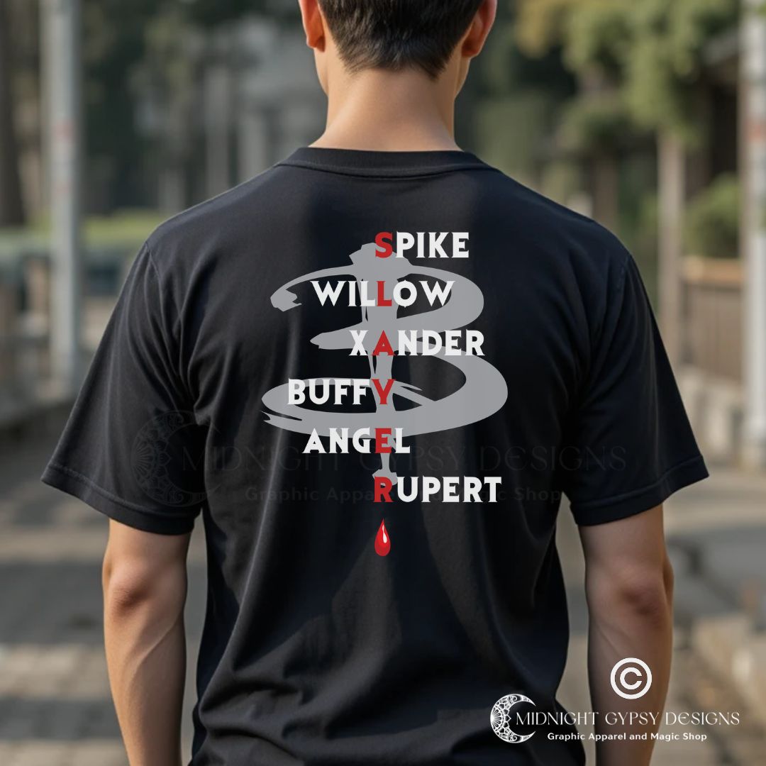 Young man with brown hair standing outside wearing a Scooby Gang Buffy the Vampire Slayer T-shirt with the character names Spike, Willow, Xander, Buffy, Angel, and Rupert on the back with the word Slayer in red and a red blood drip created by fandom graphic apparel company Midnight Gypsy Designs as part of their Buffy the Vampire Slayer clothing line.