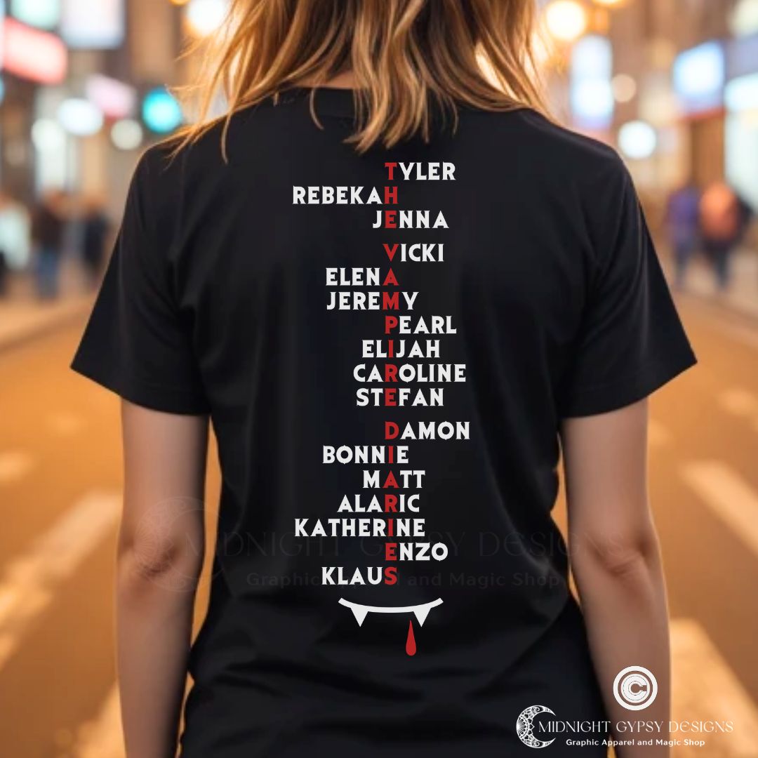Young woman with blonde hair standing in the city at night while wearing a Mystic Falls shirt with character list of names as part of the Vampire Diaries apparel line by fandom graphic shirt company Midnight Gypsy Designs.
