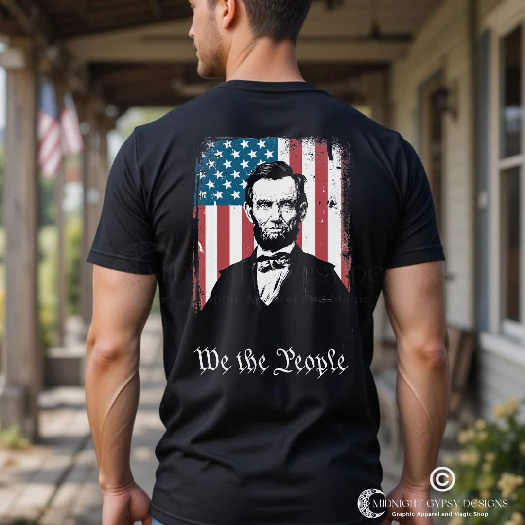 Young muscular man with short hair standing on a southern porch wearing a black We the People shirt with Abraham Lincoln with the USA flag. Perfect Abraham Lincoln shirt or USA military shirt for true patriots created by graphic apparel company Midnight Gypsy Designs.